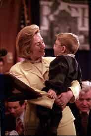 Hillary Rodham Clinton stands holding Ryan Moore.