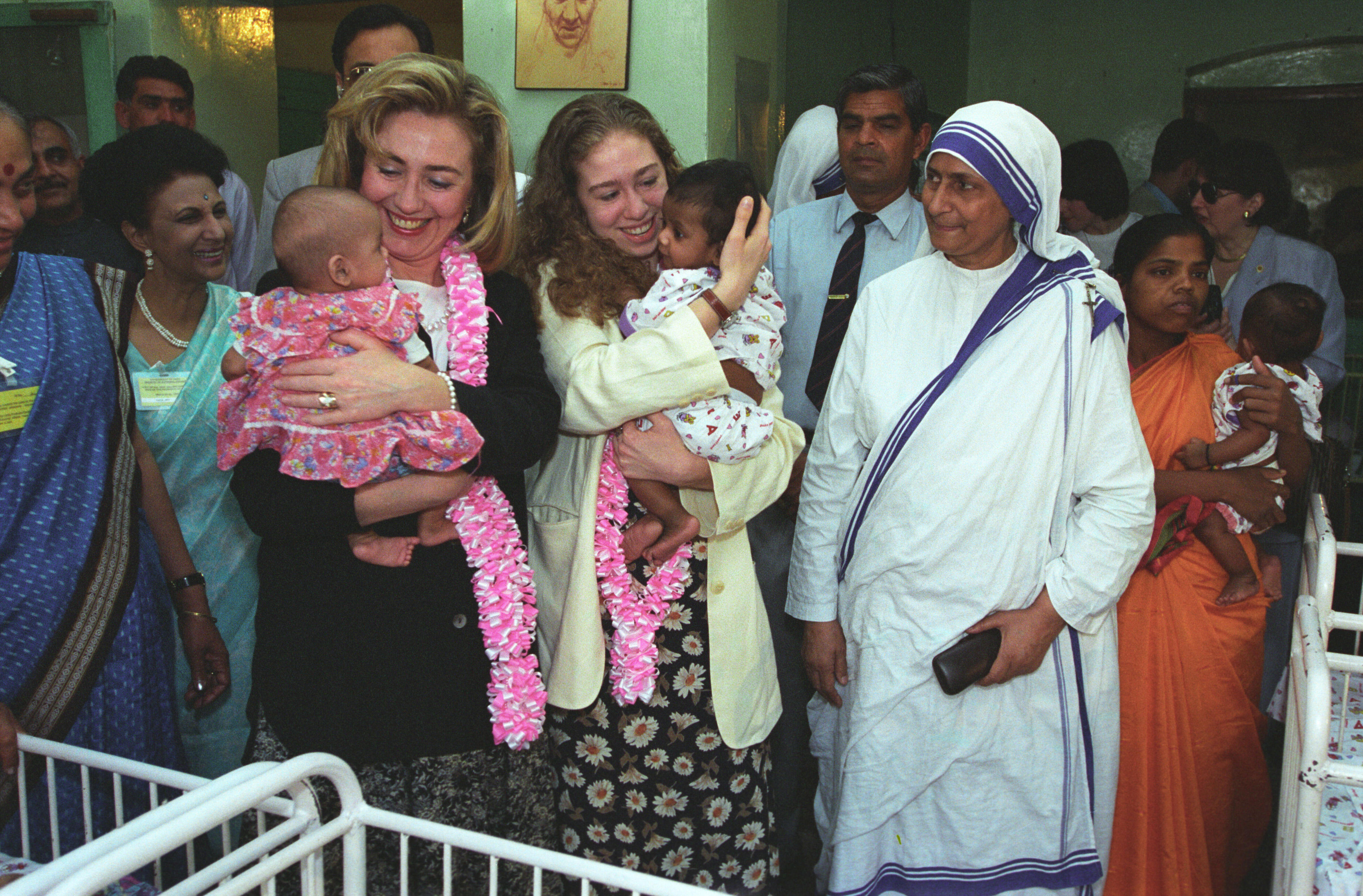 Hillary Rodham Clinton and Chelsea Clinton hold babies at Mother Teresa's Orphanage in New Delhi, India