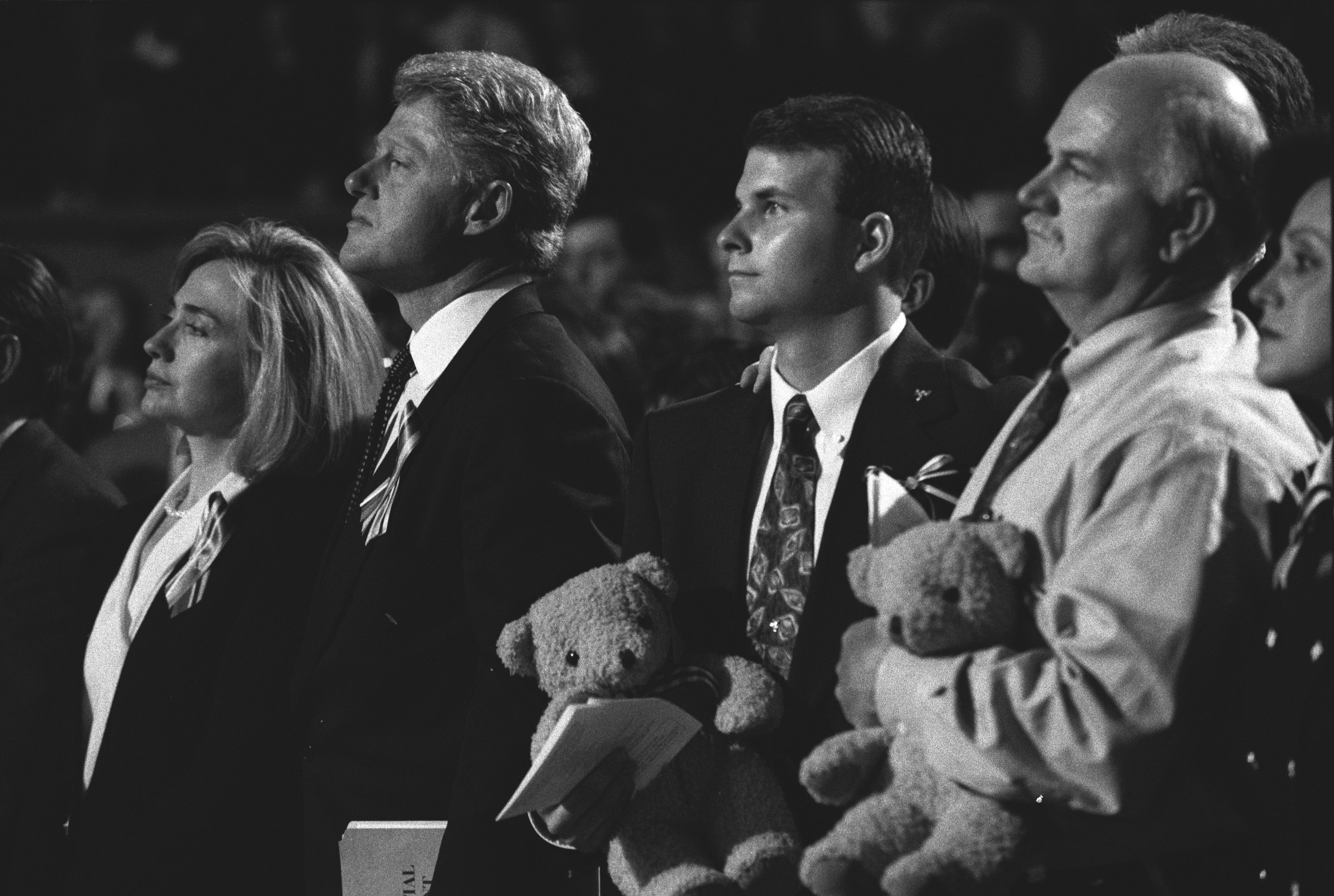 Two men hold teddy bears next to President Clinton and First Lady Hillary Rodham Clinton at the memorial service for victims of the the bombing of the Murrah Federal Building in Oklahoma City