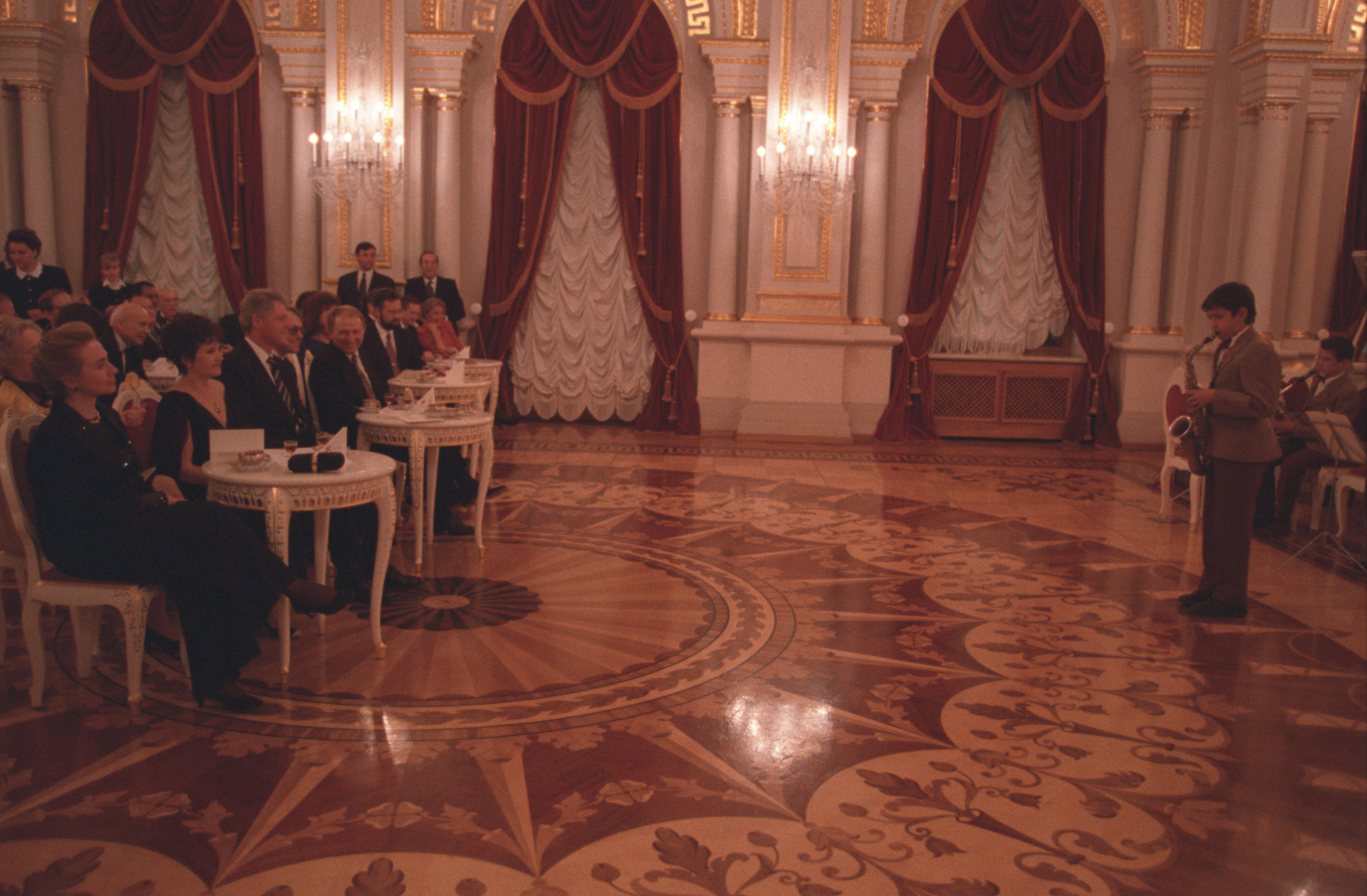 President Clinton and First Lady Hillary Rodham Clinton attend a dinner hosted by President Leonid Kuchma at Mariinskyiy Palace in Kiev, Ukraine. The Clintons and other guests listen to a Ukrainian boy playing the Saxophone