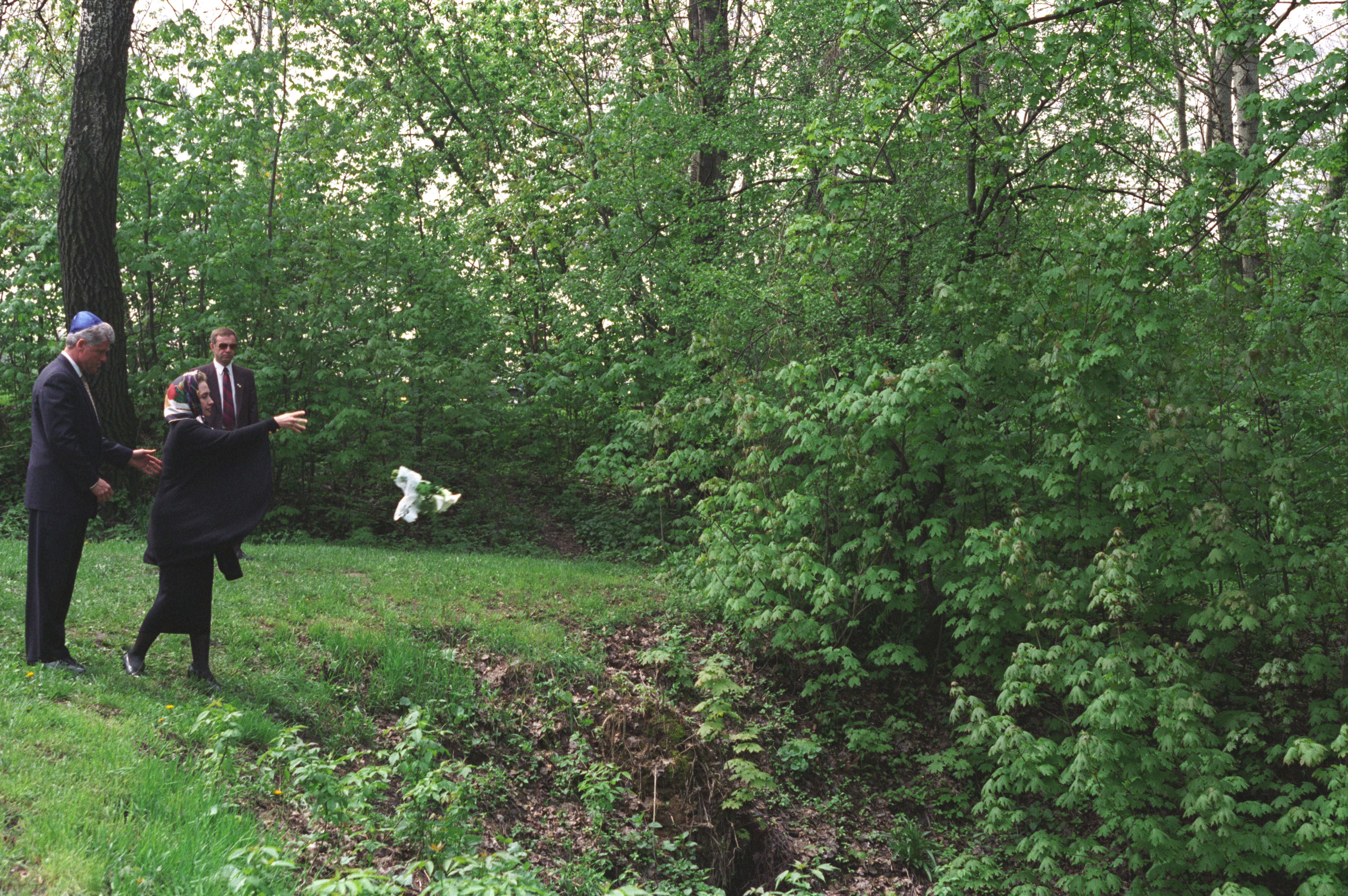 President Clinton and First Lady Hillary Rodham Clinton visit the Babi Yar World War II Menorah and Monument near Kiev, Ukraine. First Lady Hillary Rodham Clinton throws flowers into a wooded ravine at Babi Yar, a site where 34,000 Jews were killed in two days during the Nazi occupation in 1941. 