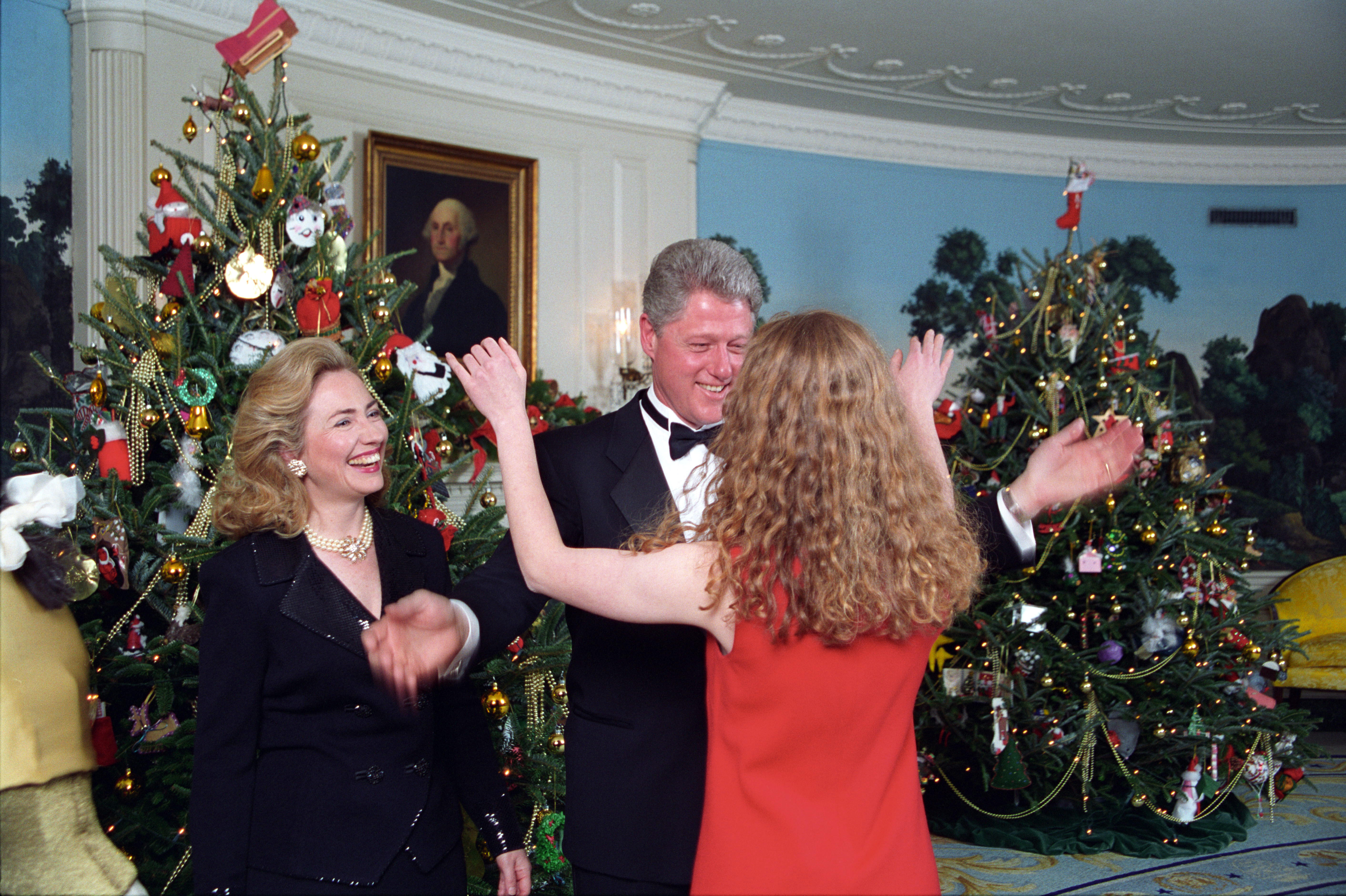 President Clinton and First Lady Hillary Rodham Clinton greet Chelsea Clinton. President Clinton faces Chelsea Clinton with his arms out. Chelsea Clinton faces Bill Clinton with her arms out, prepared to give the President a hug.