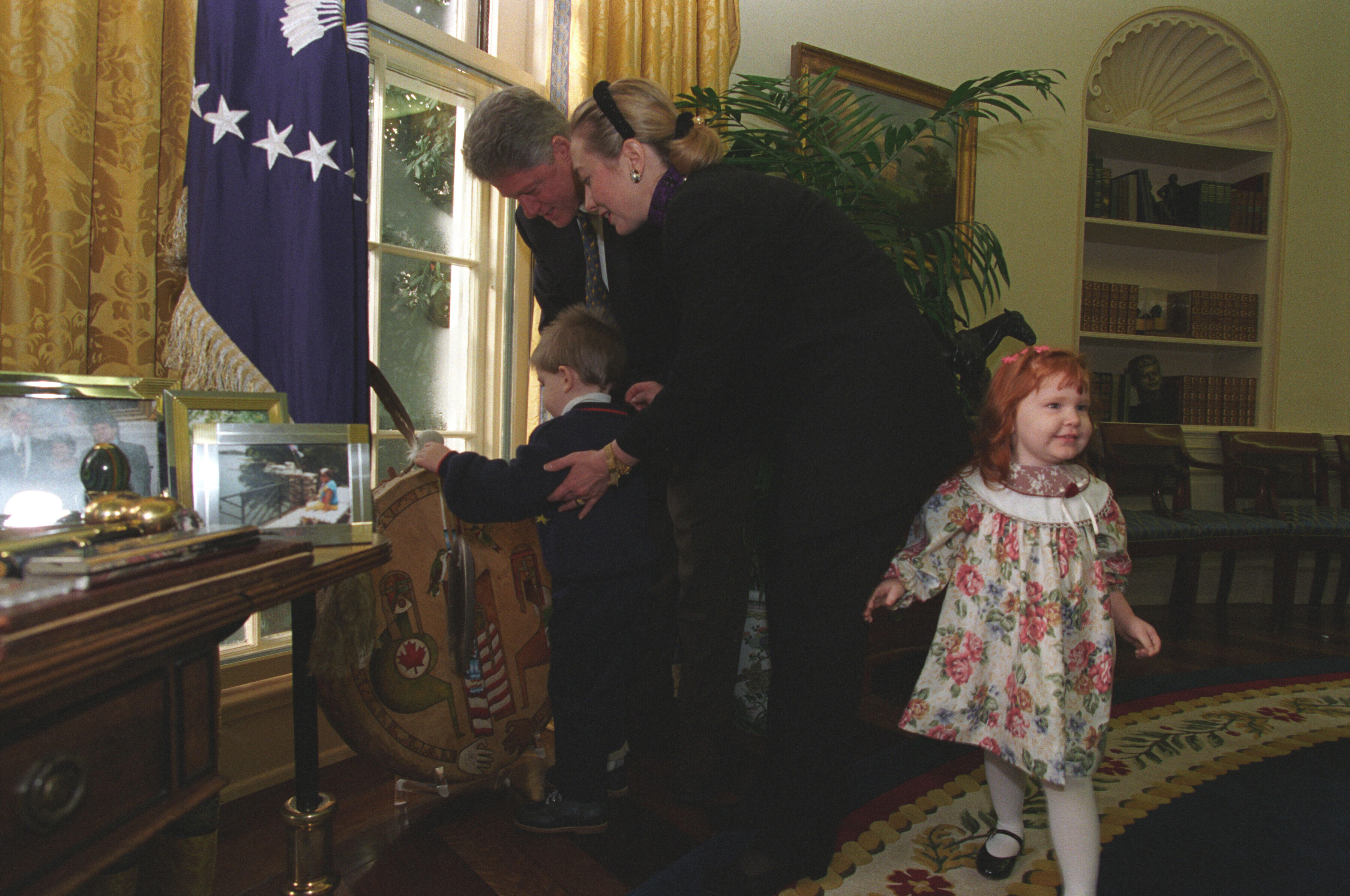 President Clinton and First Lady Hillary Rodham Clinton show photos and other items in the Oval Office to Brendon Denny and Rebecca Denny, children who were injured in the bombing of the Murrah Federal Building in Oklahoma City. The Denny family were guests at the President's Radio Address