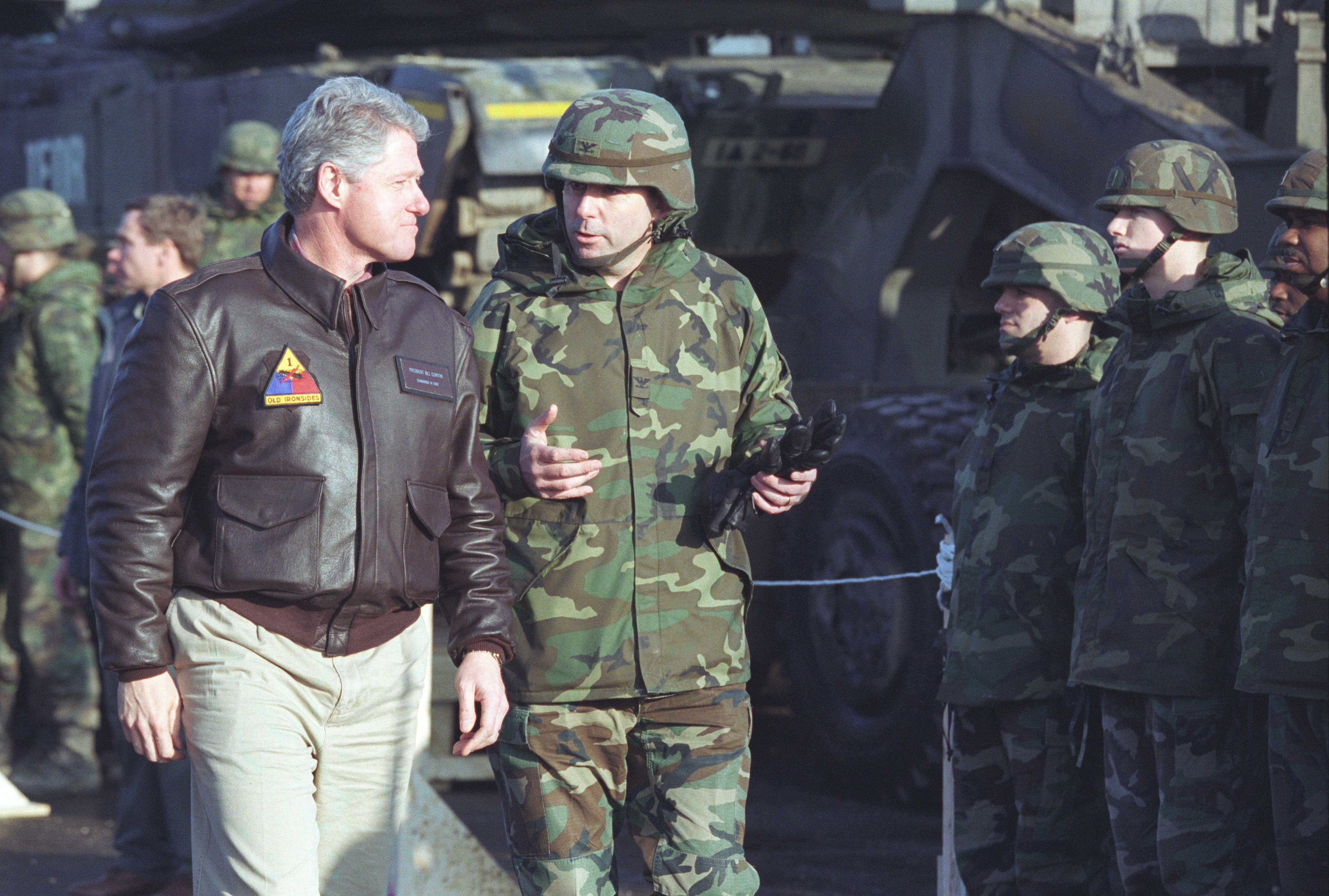 President Clinton inspects the troops in a tank convoy staging area with General William Crouch in Taszar, Hungry, January 13, 1996. President Clinton wears leather bomber Jacket and speaks to the general who is wearing military fatigues and helmet. 