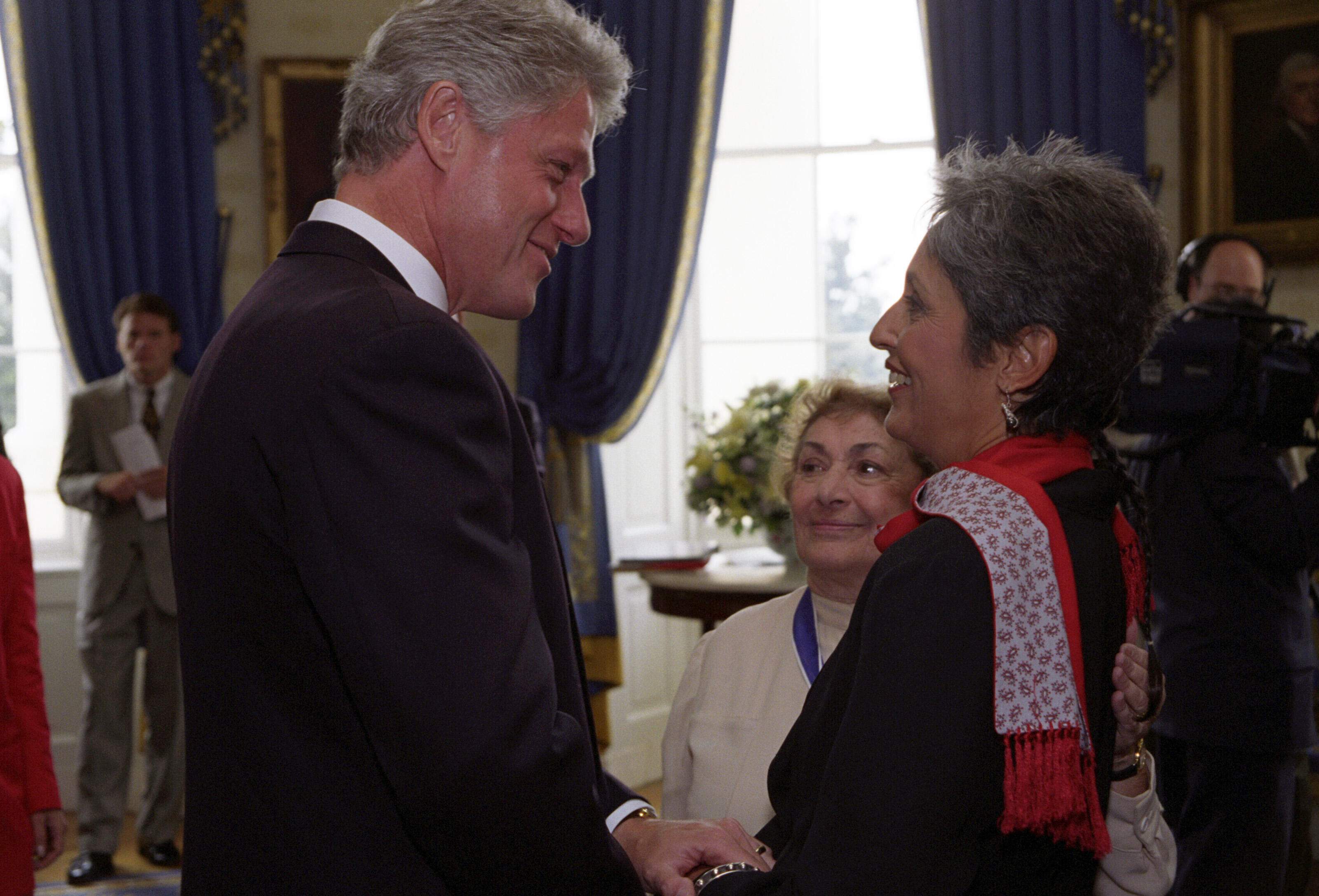 President Clinton greets singer-musician Joan Baez in a receiving line in the Blue Room of the White House during the Medal of Freedom awards