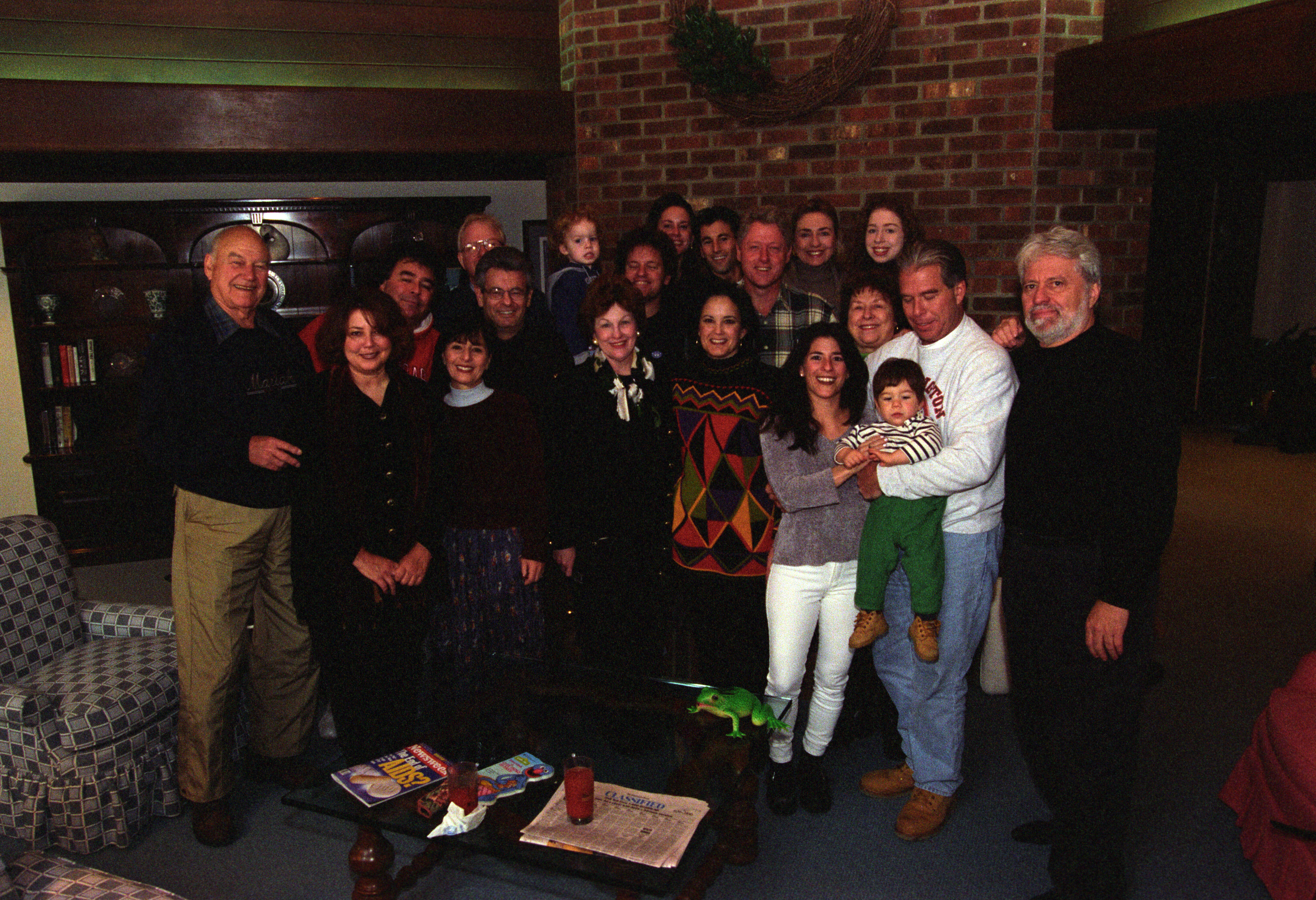 President Clinton, Hillary Rodham Clinton, and Chelsea Clinton are pictured with a large group of family and friends in the living room at Camp David.