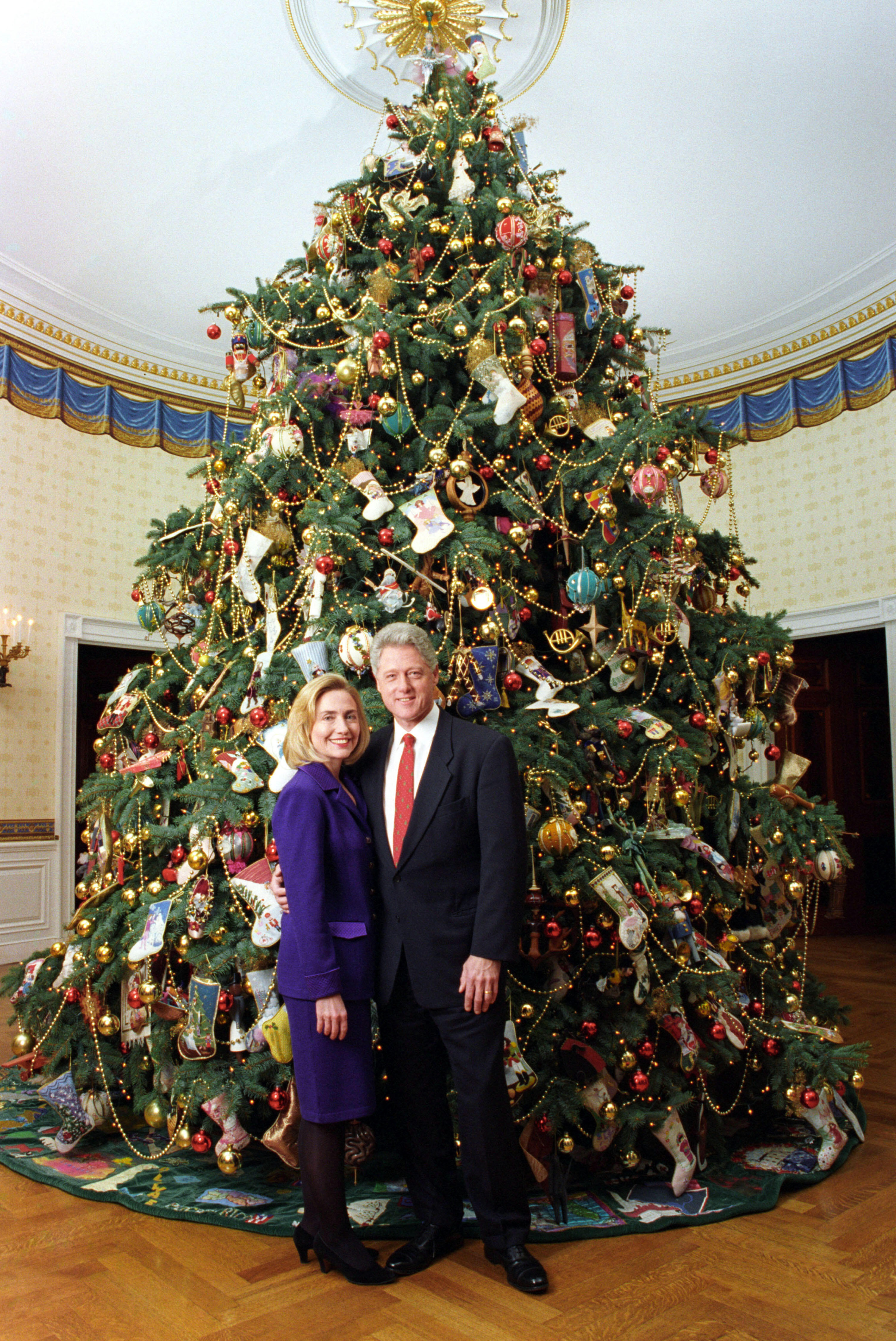 President Clinton and Hillary Rodham Clinton posing next to the 1996 White House Christmas tree