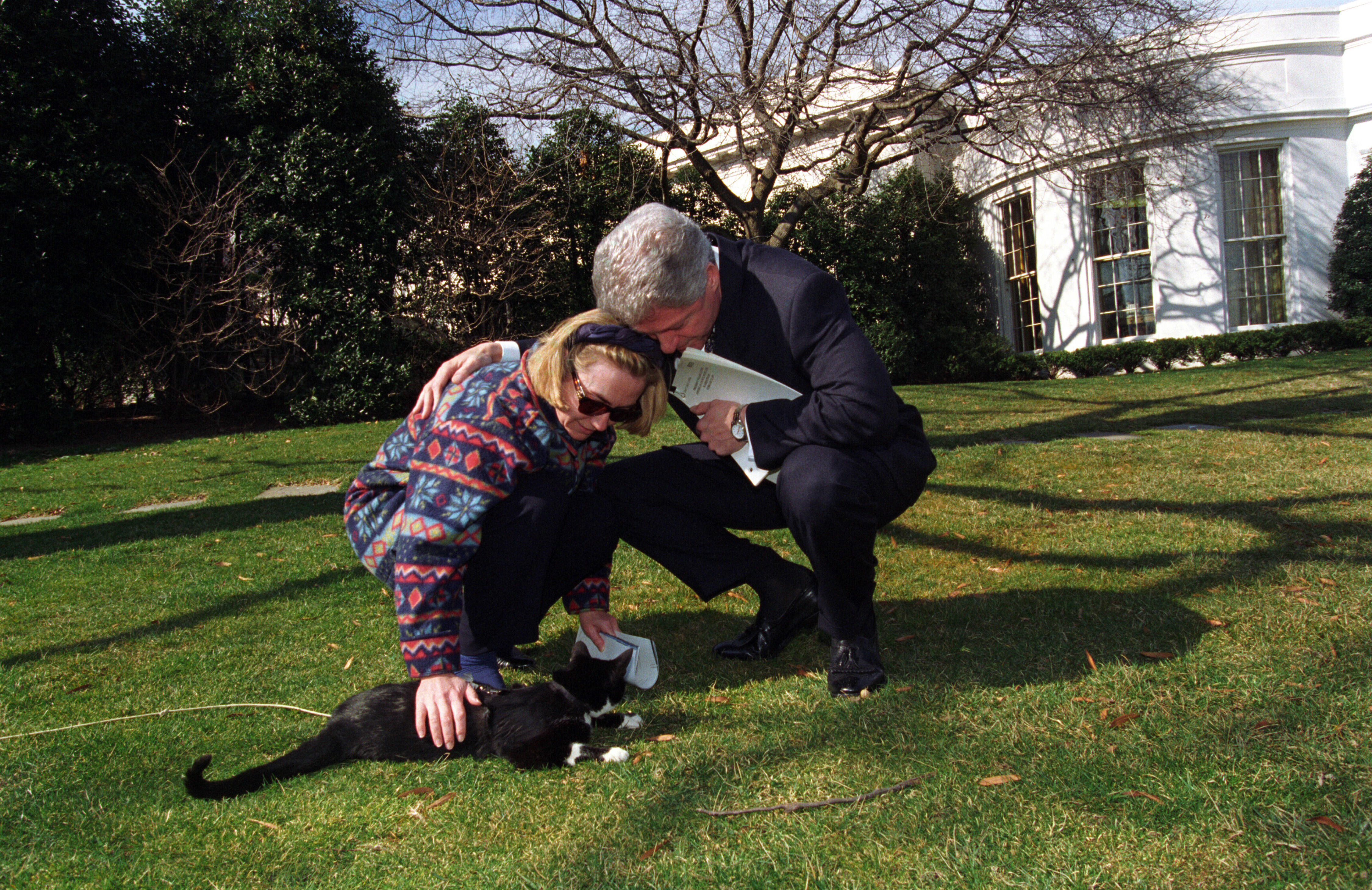 Hillary Rodham Clinton pets Socks with President Clinton on the lawn of the South Grounds of the White House