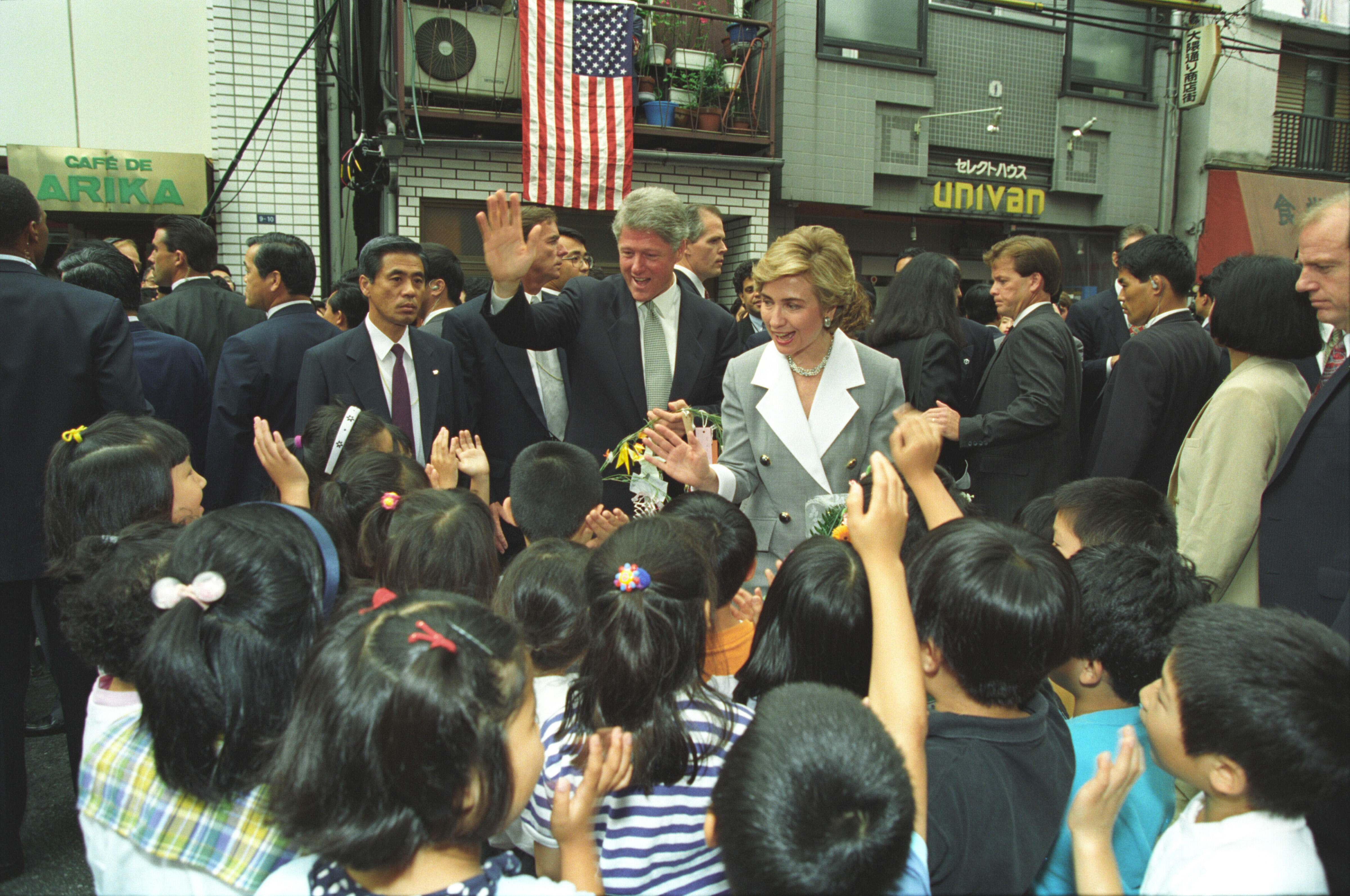 President William J. Clinton and First Lady Hillary Rodham Clinton visiting with school children in the Okuma shopping district in Tokyo, Japan. The children greet the Clintons and give the First Lady a bouquet of flowers