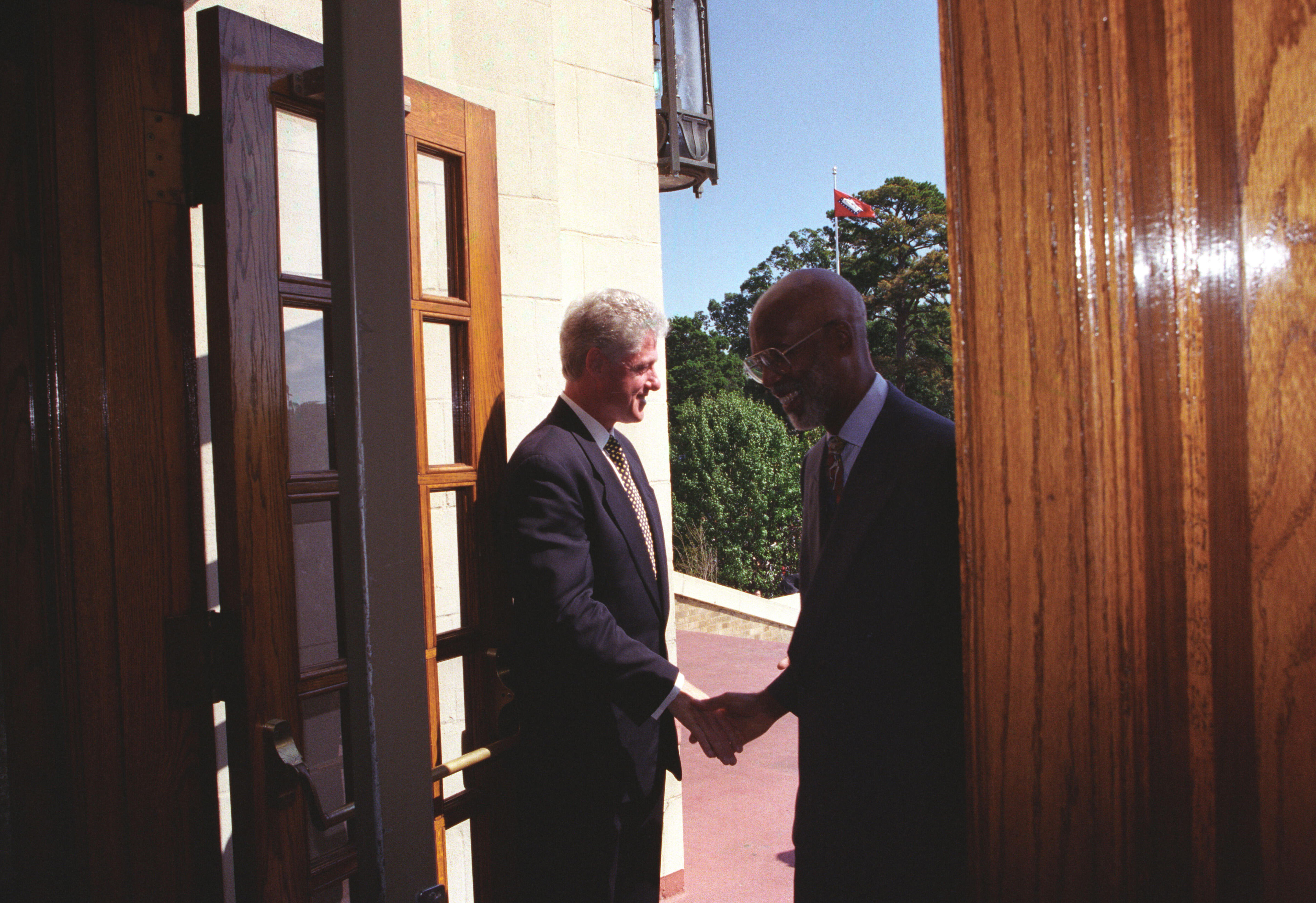 President Clinton holds the door open to Central High and greets Terrence Roberts as he enters the school