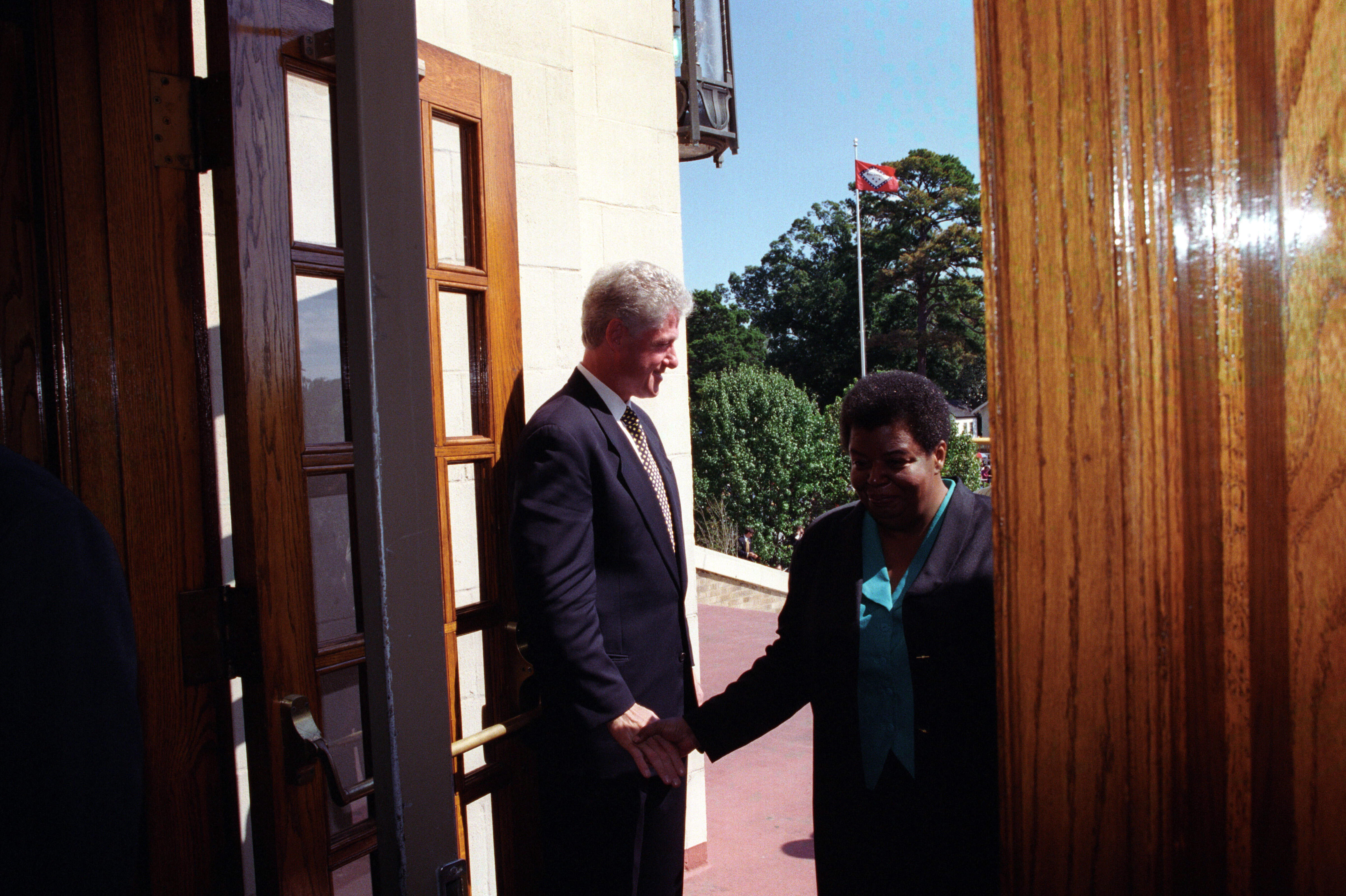 President Clinton holds the door open to Central High and greets Elizabeth Eckford as she enters the school