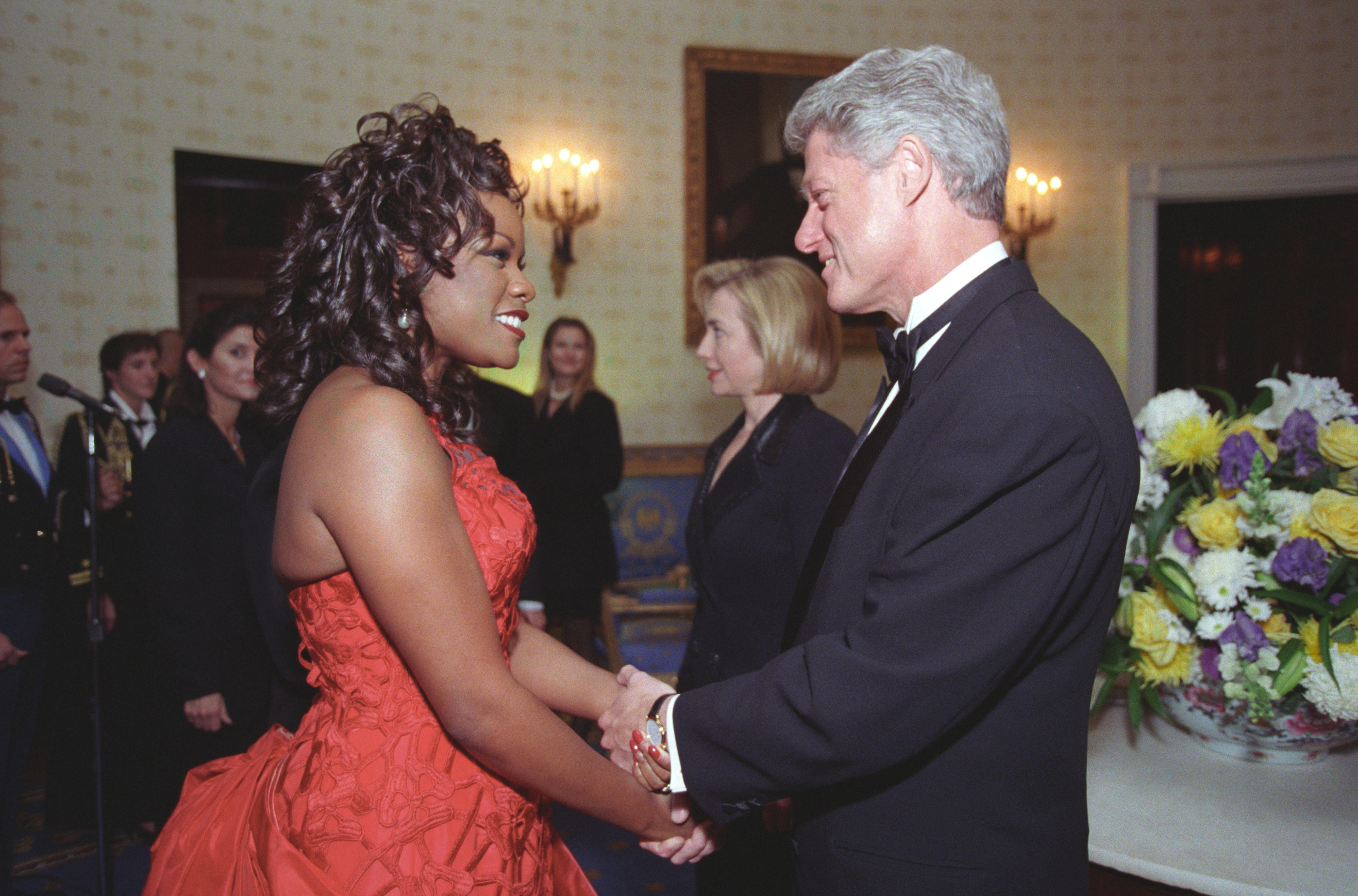 President Clinton greets mezzo-soprano opera singer Denyce Graves in a receiving line in the Blue Room of the White House during the NPR anniversary event