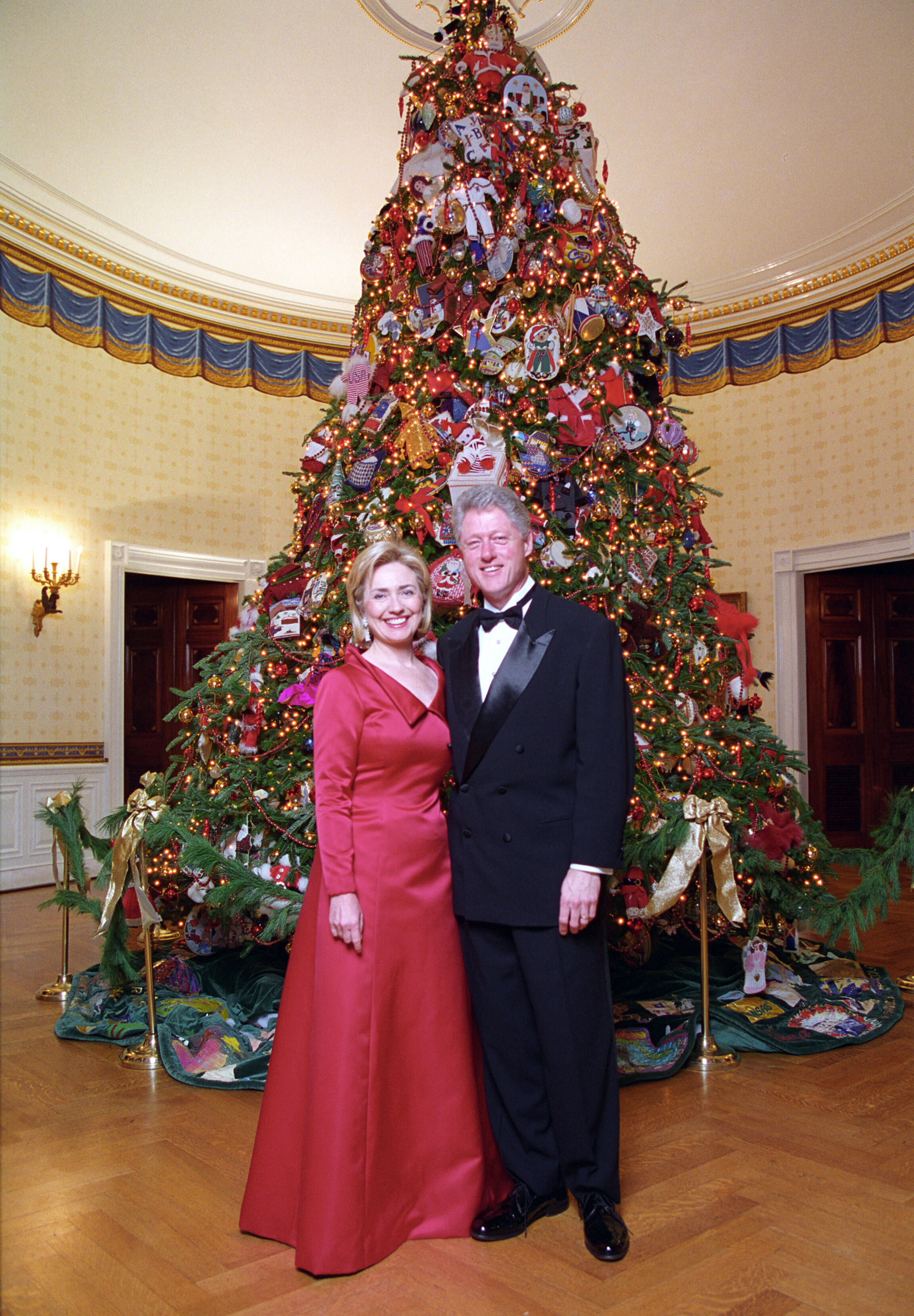 President Clinton and Hillary Rodham Clinton posing next to the 1997 White House Christmas tree.