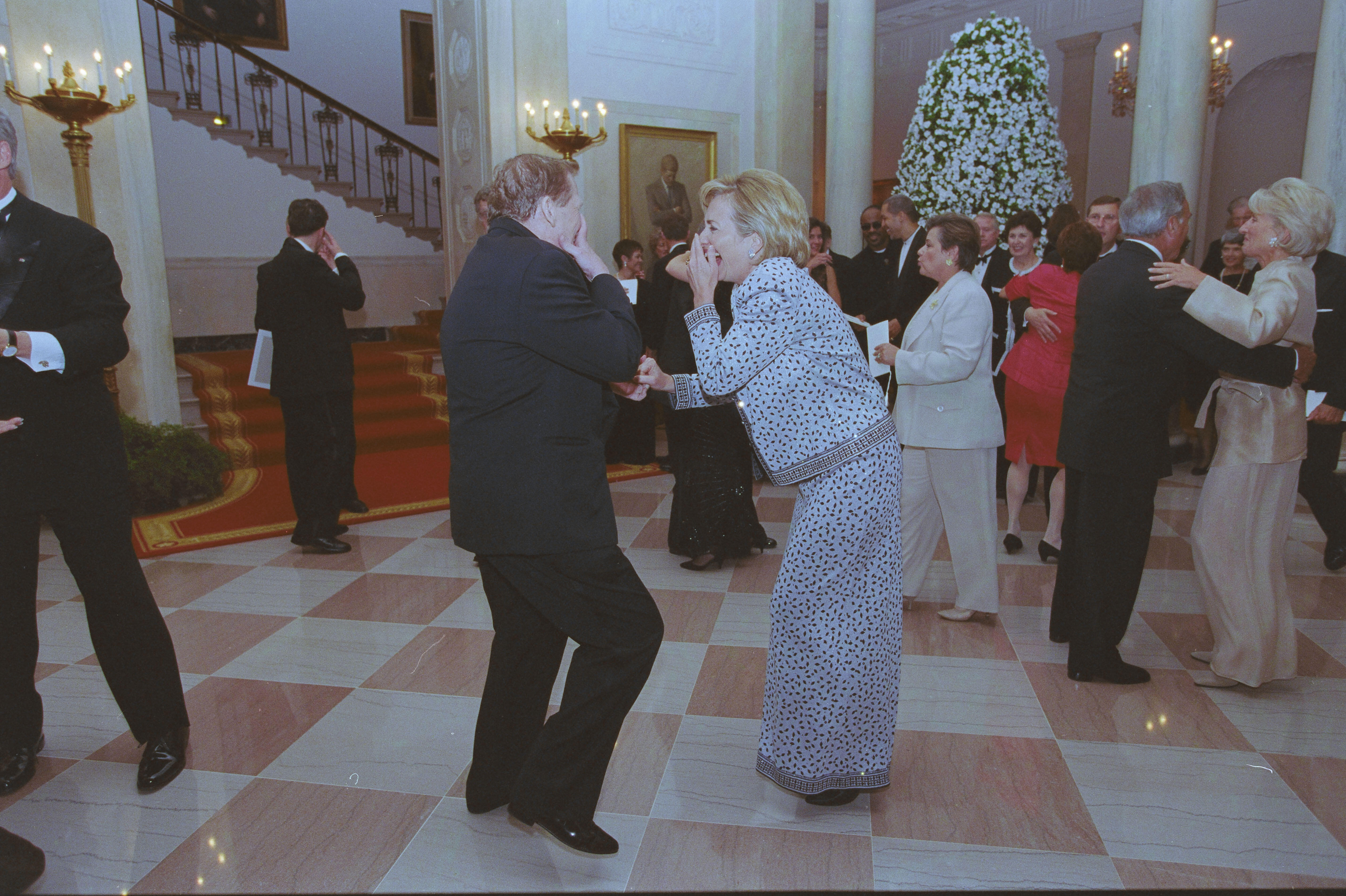 First Lady Hillary Rodham Clinton and President Václav Havel dance and laugh together. Other State Dinner attendees dance in the background. 