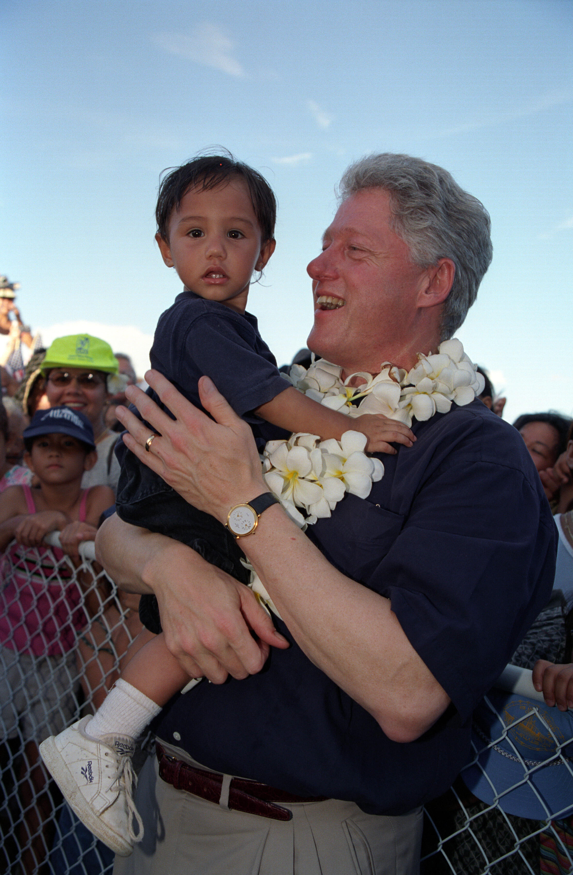 President Clinton holds a young boy in his arms following his address to the people of Guam