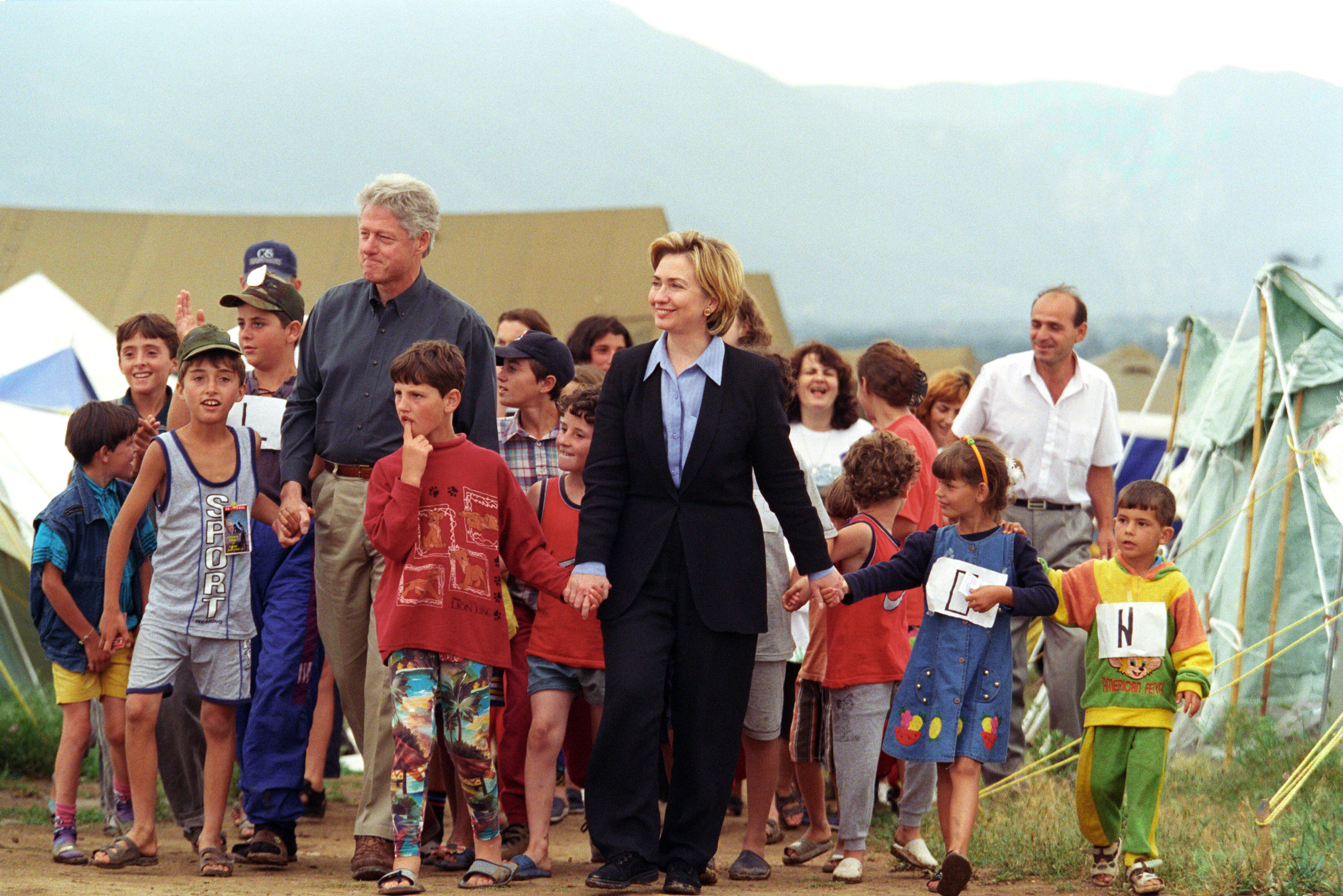 President Clinton and Hillary Rodham Clinton walk through Stenkovic 1 Refugee Camp with young Kosovar refugees near Skopje, Macedonia