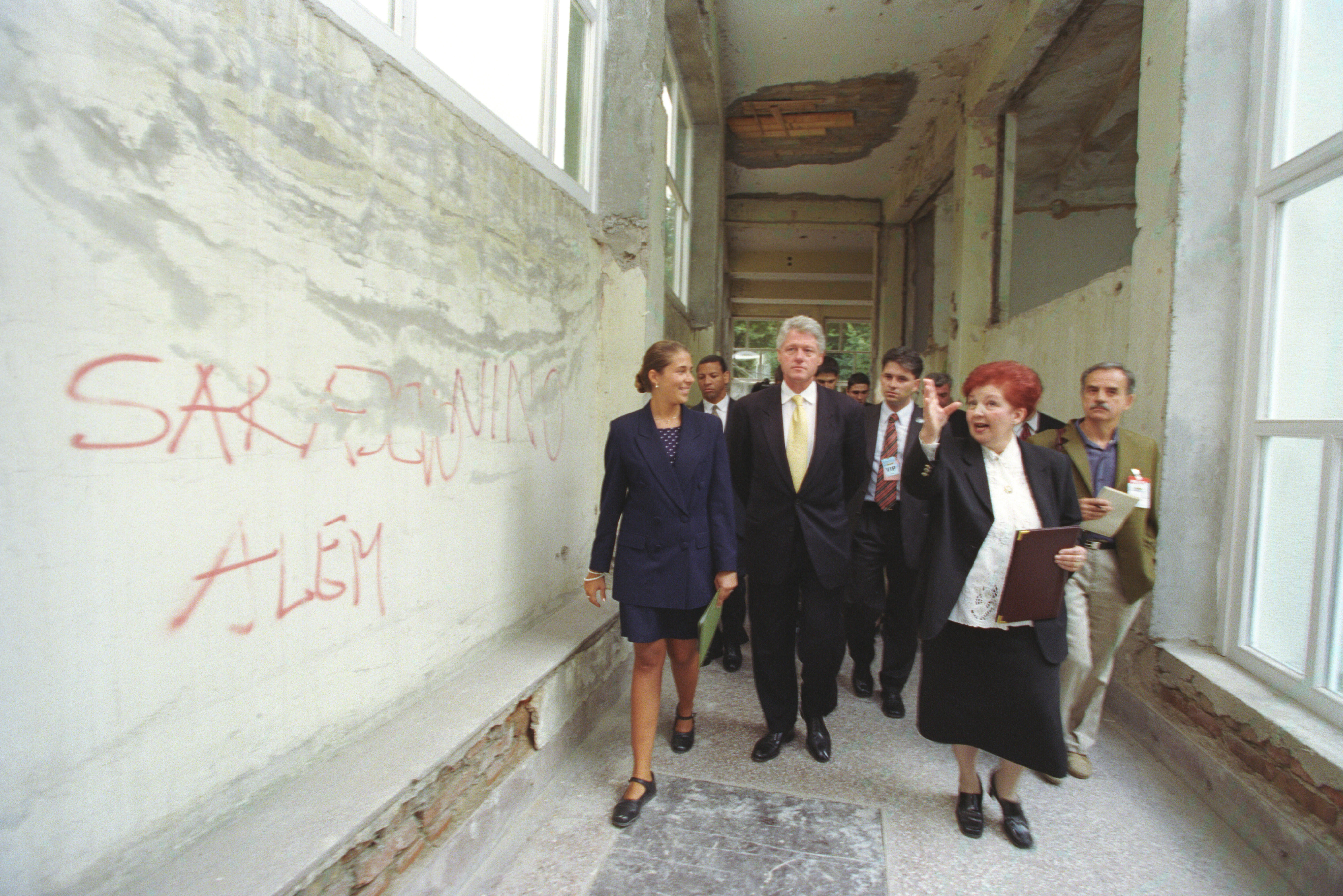 President Clinton tours Third High School in Sarajevo, Bosnia-Herzegovina. The President is accompanied by the school's principal, Adnan Memic. The walls of the school have been graffitied