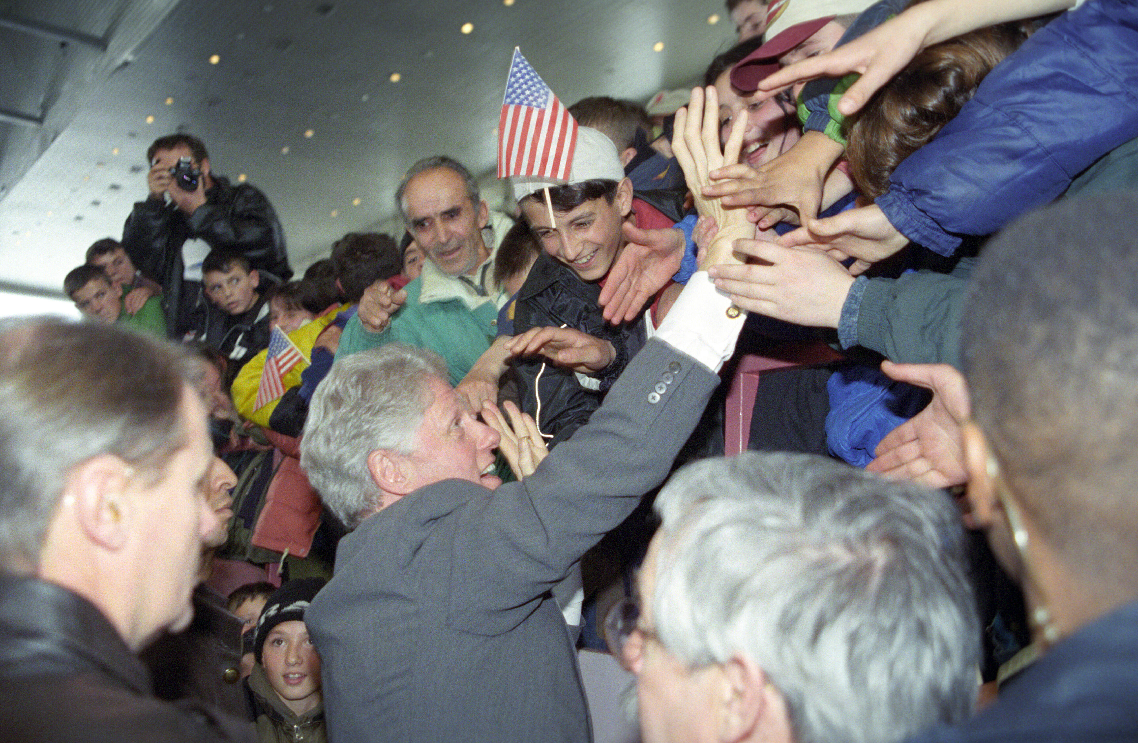 President Clinton shakes hands with people in the crowd at the Ferizaj Sports Pavilion in Ferizaj, Kosovo