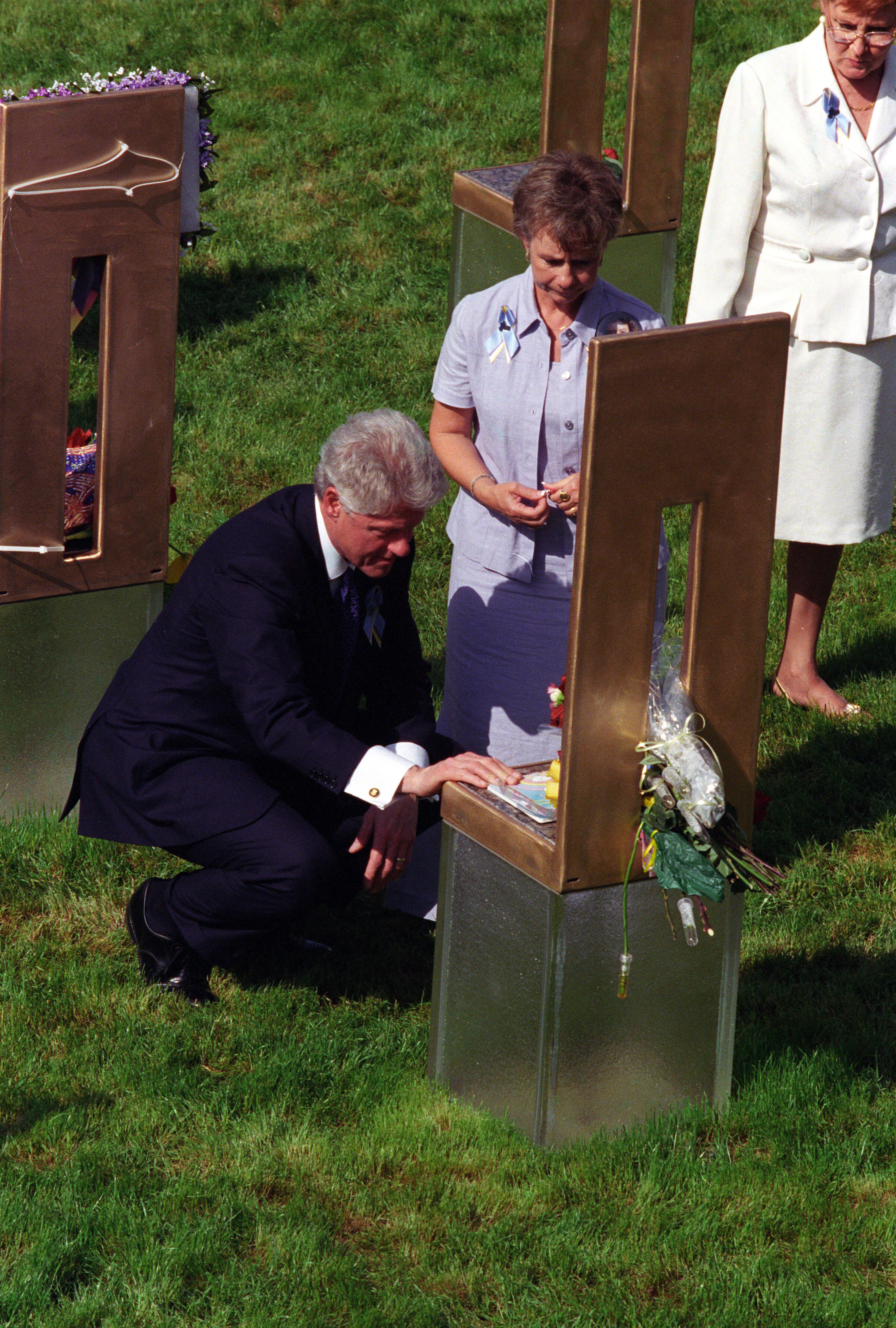 President Clinton stoops down and touches a chair at the Oklahoma City National Memorial