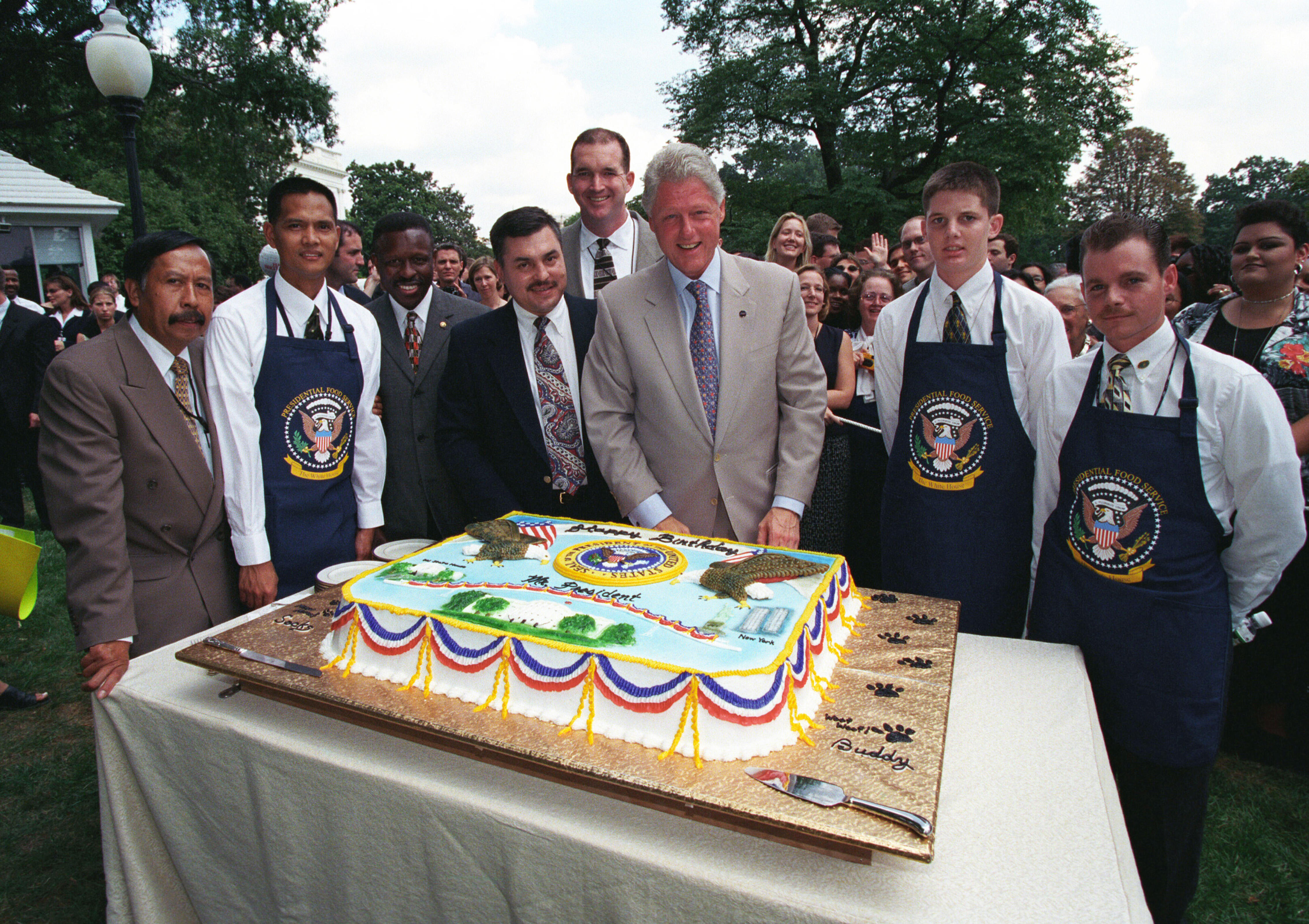 President Clinton looks at his birthday cake with creator Glen Maes and the White House Mess Personnel on the South Lawn of the White House