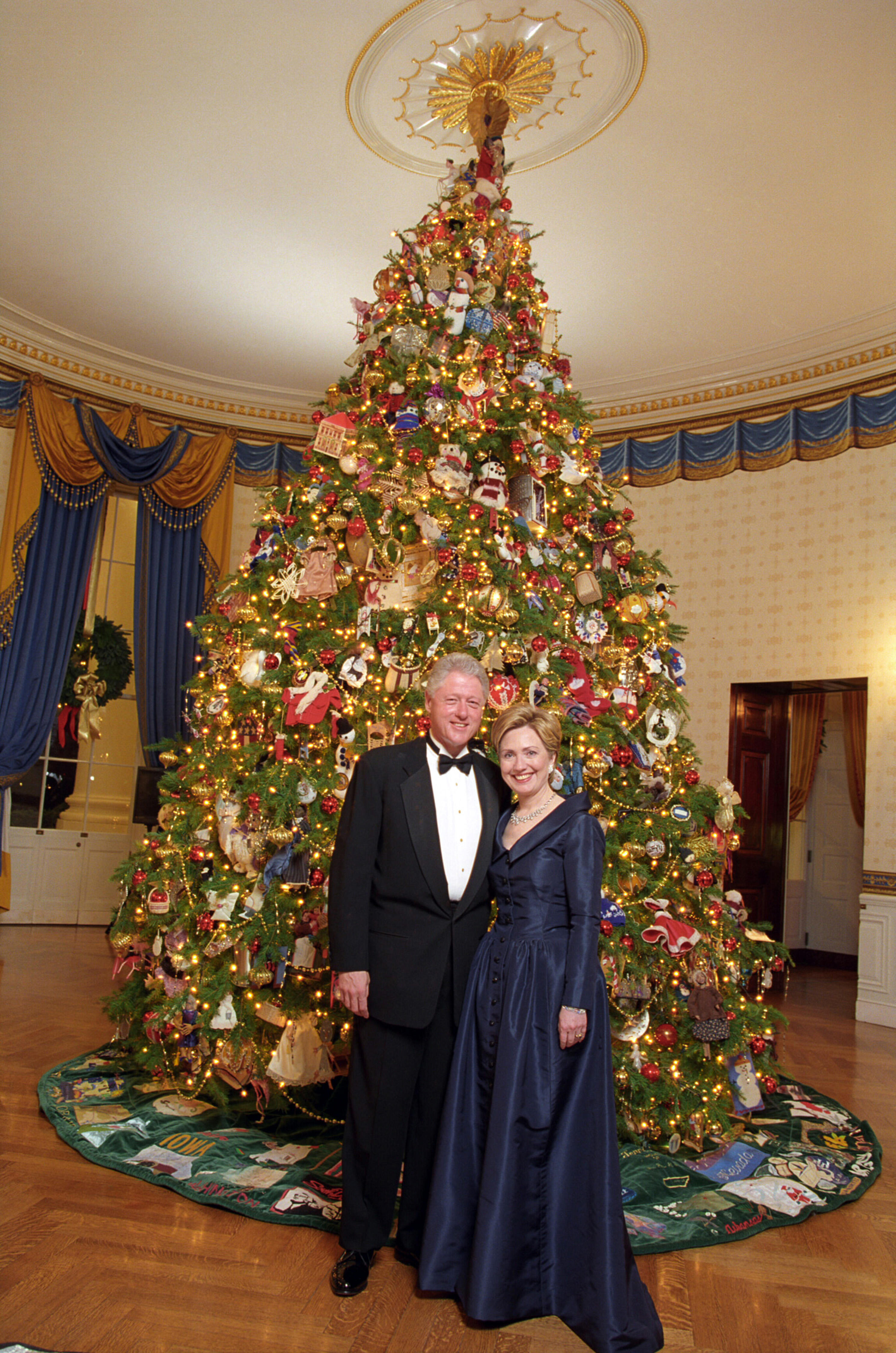 President Clinton and Hillary Rodham Clinton posing next to the 2000 White House Christmas tree